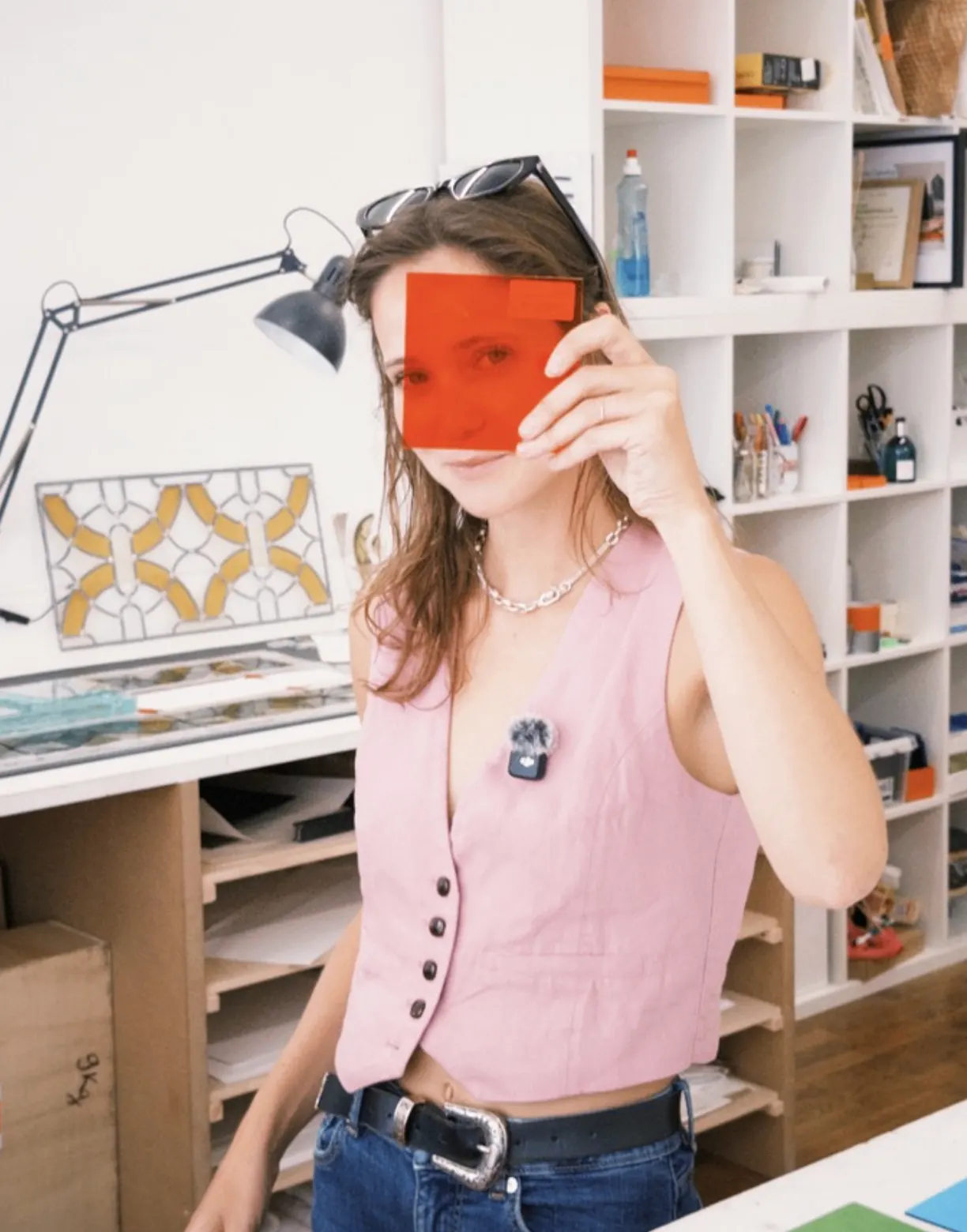 Portrait dans un atelier avec un filtre rouge tenu devant le regard